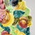 A colorful jewel toned majolica platter decorated with various embossed fruits such as peaches, grapes, tomatoes, pears...