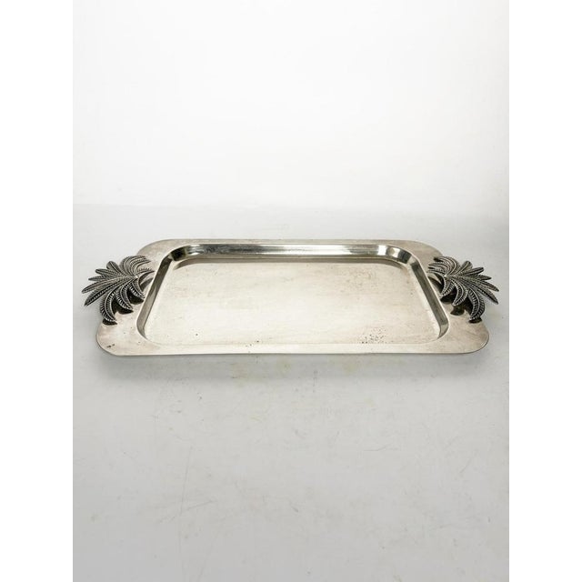Large rectangular silver-plated platter, adorned at each end with a spectacular design of stylized palm trees in relief....
