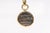 A bronze coin pendant trimmed in 18 karat gold. This coin is from the Kingdom of Macedon, circa 331-323 BC. On the obverse...