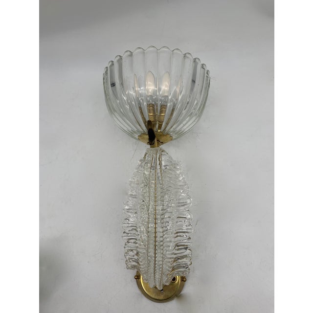 Pair of Murano blown glass appliques, handcrafted with transparent curved arm and brass relief decoration, mounted on a...