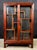 This Chinese rosewood display cabinet has two glazed front doors and glass panels on the sides and rear, with an...