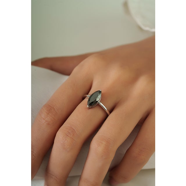 This solitaire ring features a 1.96-carat marquise-cut black diamond set in 14K White Gold. The diamond measuring 6 x 11.5...