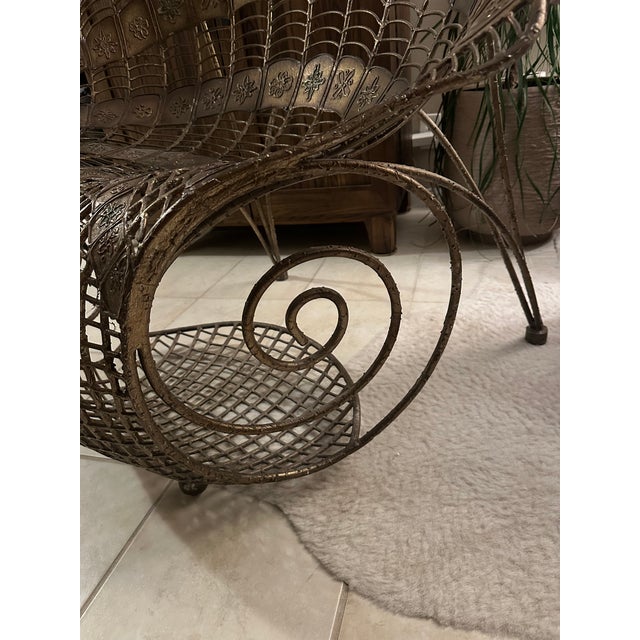This Large Wrought Iron Chair with Peacock Design showcases a dramatic and ornate fan-shaped form that mimics a peacock's...
