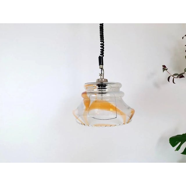 A beautiful hanging orange/white light. Made in the 70s in Yugoslavia. The lamp is in mid-century style and gives the room...