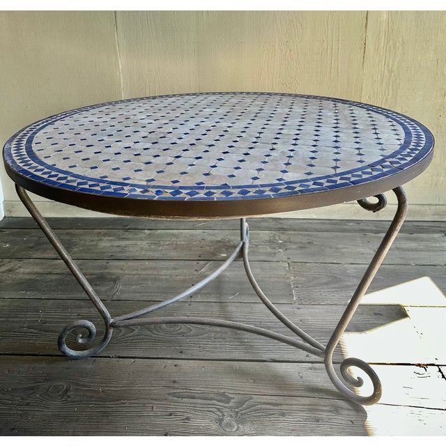 Beautiful Moroccan tiles that are presumably hand made are inset into this 47" diameter tabletop. It rests on a one-piece...