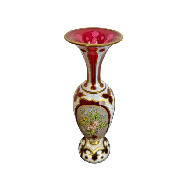 An elegant Bohemian antique cut glass vase featuring rich cranberry color, white overlay, three hand-painted enamel floral...
