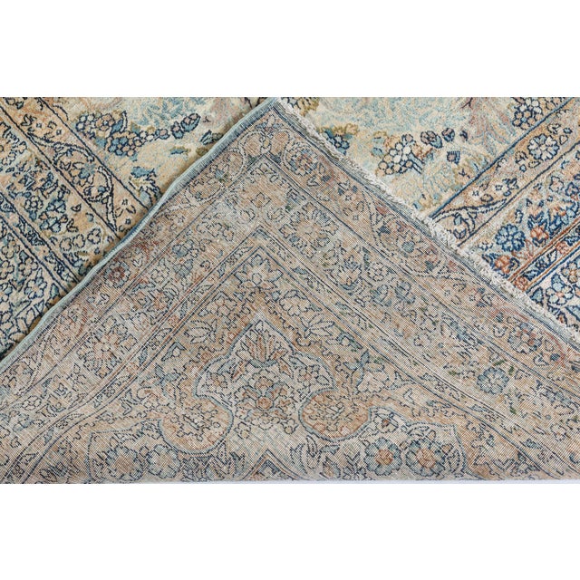 An early 20th century Persian Kirman rug, the ice blue field with an allover designs of floral swags and trailing leaves...