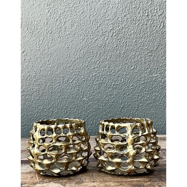 Defined by raw geometric texture and sculptural impact, this pair of vintage Brutalist candle holders features heavy cast...