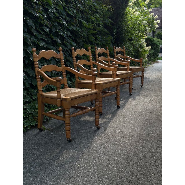 Four Dutch dining chairs in beech frame with rush seats on casters. Ladder-back with turned legs, stretchers and spindles....