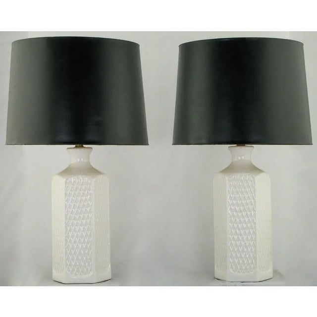 Pair of hexagonal white ceramic vessel table lamps with a raised relief of open triangles (or Vs) on every side. Sold sans...