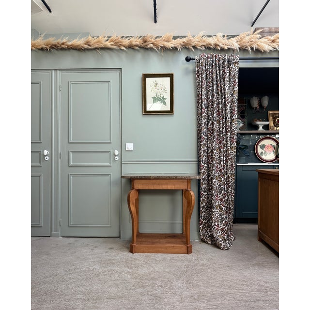 This antique louis-philippe walnut console table is distinguished by its curved legs and narrow proportions. It is now...