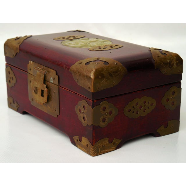 An ornate Mid-20th Century Chinese jewelry casket crafted from dark rosewood (or mahogany) with a rich red finish. The lid...