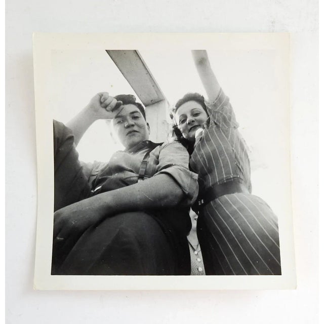 Circa 1950's snapshot of a couple shot from below unique angle. 3rd person peaking from between no notes, 4" sq. good...