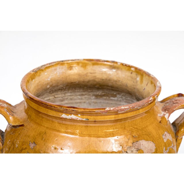 An earthenware confit pot from the Southwest of France with traditional yellow, ochre glaze, ridged rim and twin handles....