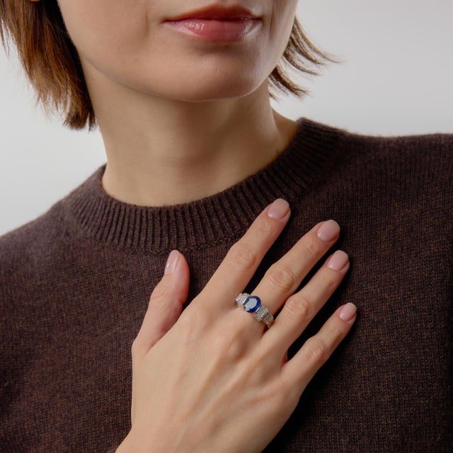 This vintage sapphire and diamond ring is a powerful statement of color and structure. At its center rests an oval cut...