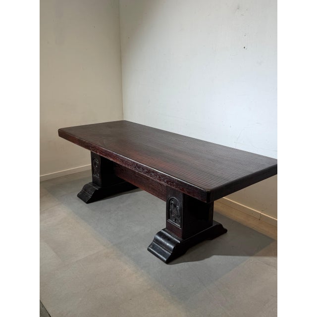 Beautiful antique solid oak dining table featuring a robust construction and rich, dark patina. The table stands on two...