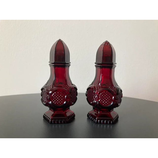 A beautiful pair of salt and pepper shakers with geometric design in ruby red glass, circa mid to late 20th century, USA....