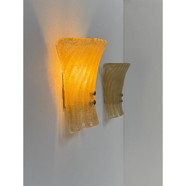 Pair of wall sconces with a molded, pressed structure in Murano glass, produced in Italy in the 1980s. Exceptional glass...