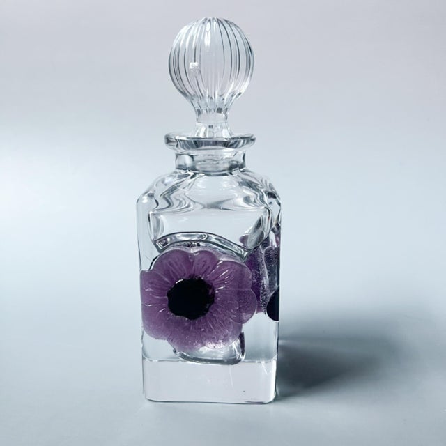 A signed Daum France crystal perfume bottle from the Coppelia series, featuring a deeply carved floral motif in rich...