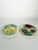Charming pair of French majolica ceramic plates featuring two distinct hand-painted botanical designs. One plate is...