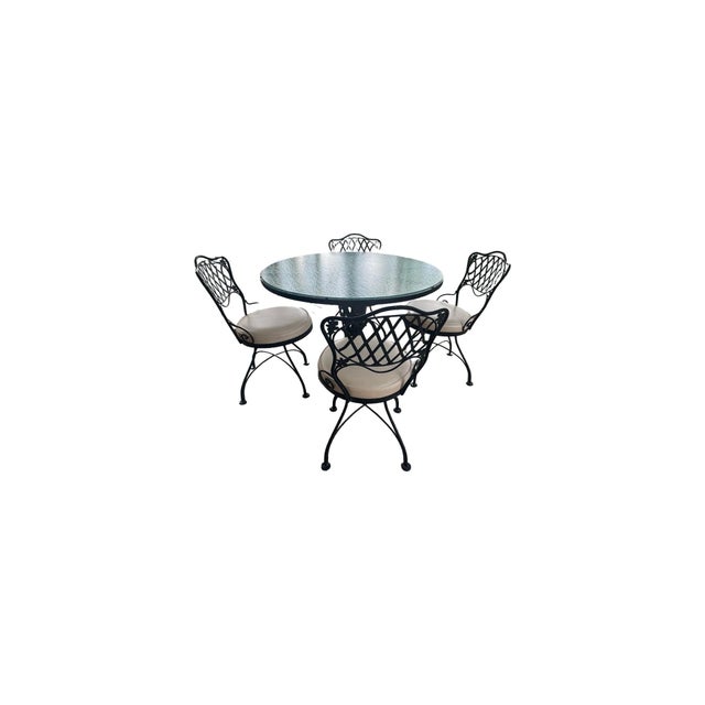 Vintage Woodward wrought iron patio set. Glass top table with 4 chairs. Suitable for covered patio with heavy duty vinyl...