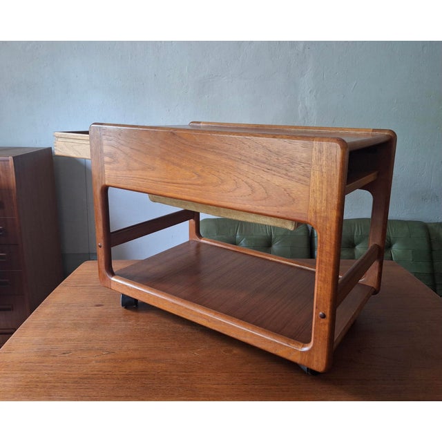 1960s bar cart / serving trolley in teak with a drawer that can be opened from both ends; and a suede holder / bag that...