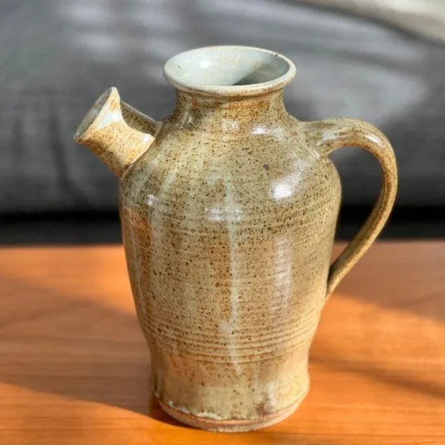 Gorgeous, well-crafted pottery pitcher with the artist's signature, "Staub". The pitcher has a brown-speckled glaze with a...
