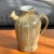 Gorgeous, well-crafted pottery pitcher with the artist's signature, "Staub". The pitcher has a brown-speckled glaze with a...