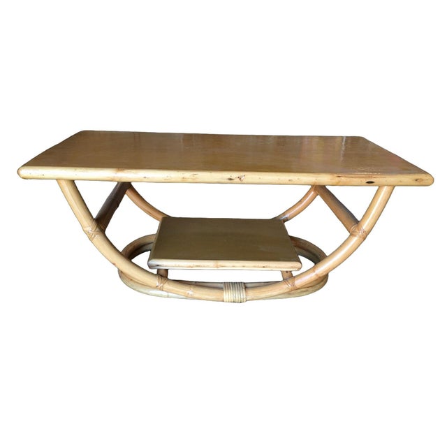 Restored Mid-Century two-tier coffee table featuring an oval rattan frame and Philippine mahogany wood top. The wood top...