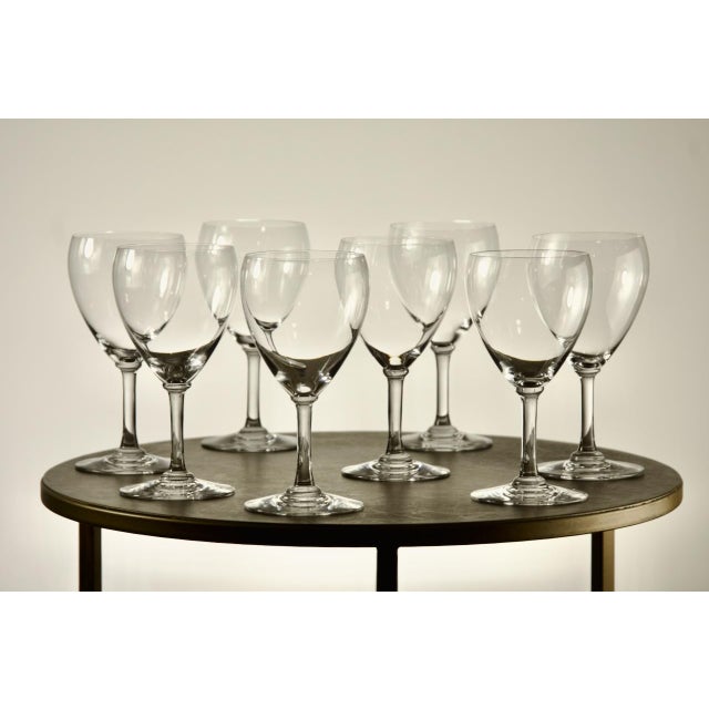 A set of eight French crystal white wine glasses by Baccarat, each signed on the underside of the foot with the acid-...