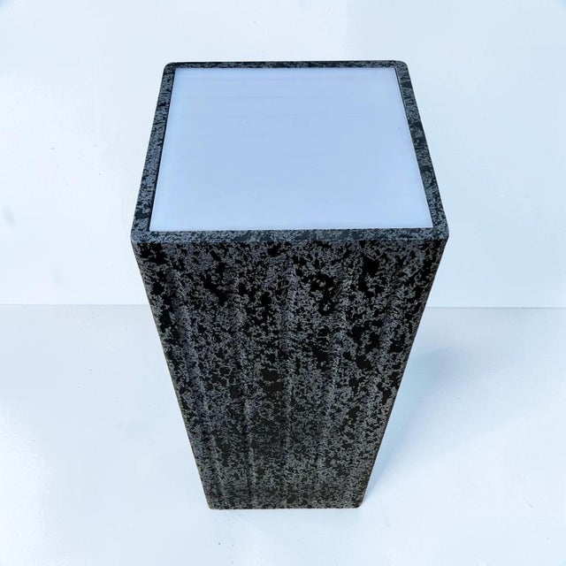 1980s postmodern pedestal, with a textured black and gray finish. This piece has a white acrylic top that can be...