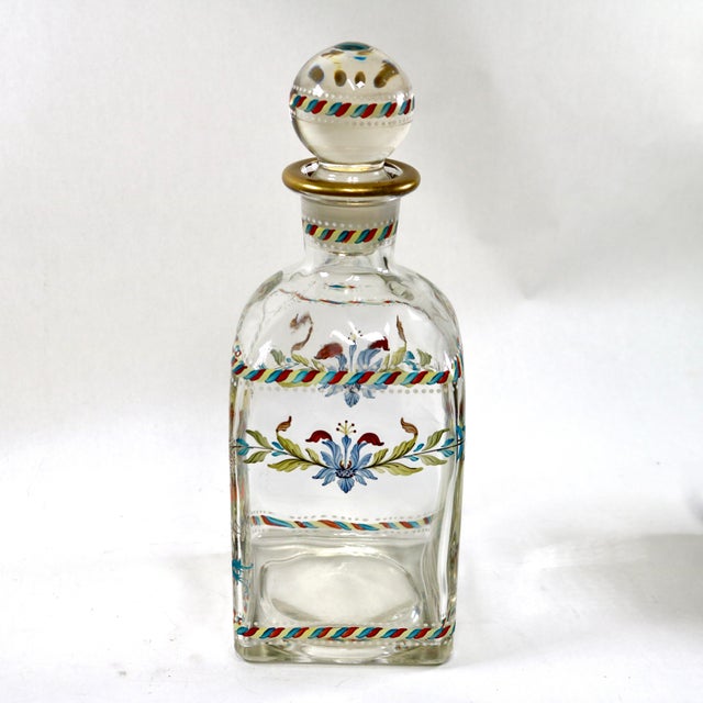 This elegant hand-blown glass decanter, crafted in Portugal during the 1950s-60s, boasts a vibrant floral motif delicately...