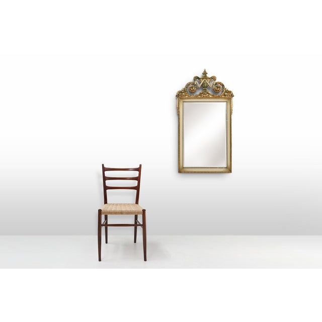 An elegant French wall mirror crafted in the 1950s, inspired by the richly decorative aesthetics of the Napoleon III...