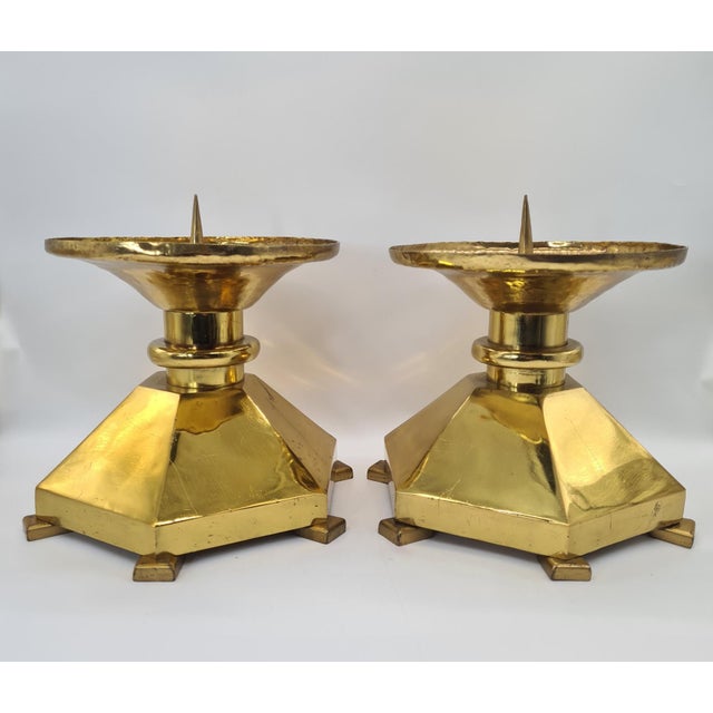 A striking pair of large, heavy brass candlesticks in the Brutalist style, originating from Europe and dating from around...