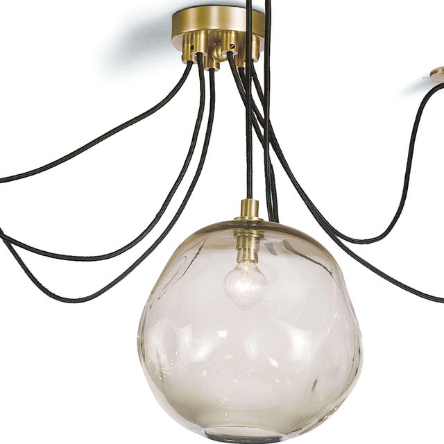 This chandelier’s hand-crafted glass shades suspended from rope cords lend a distinct, artisan effect that can create a...