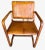 Beautifully patinated camel color leather chair with two matching antiqued cast-brass buckle details on the back. The...