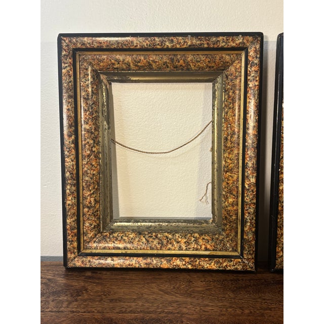 A striking pair of late 19th century Eastlake or Victorian-style picture frames featuring a richly layered faux marble or...