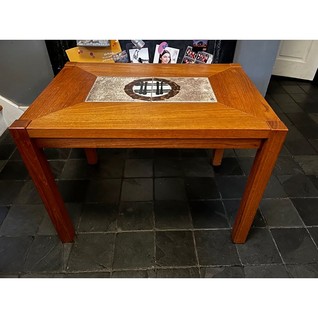 Stylish midcentury oblong table that can be an end or coffee table. Nice ceramic center detail and teak wood with...