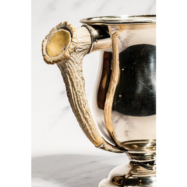 Dating to circa 1915, this striking antique trophy cup combines the refinement of sterling silver with the rugged beauty...