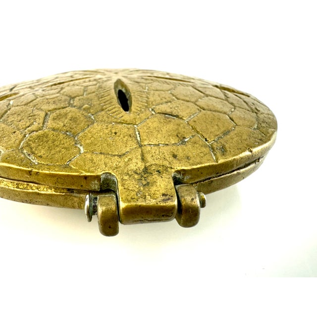This charming vintage brass trinket box captures the intricate beauty of a sand dollar, adding a coastal touch to any...