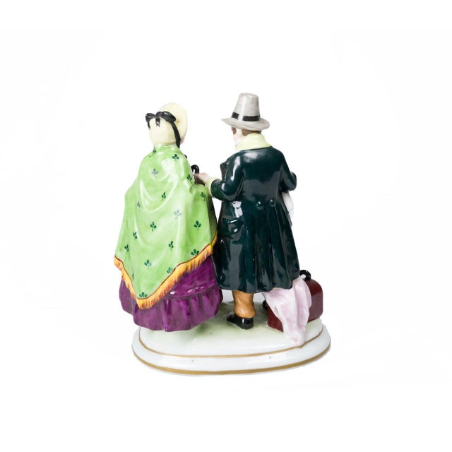 This late 18th-century Capodimonte figurine, depicting a traveling couple with suitcases, crafted from fine translucent...