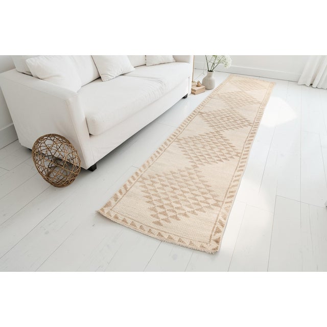 This is a vintage Turkish Oushak rug from the Mid 20th Century. The piece was hand-knotted.