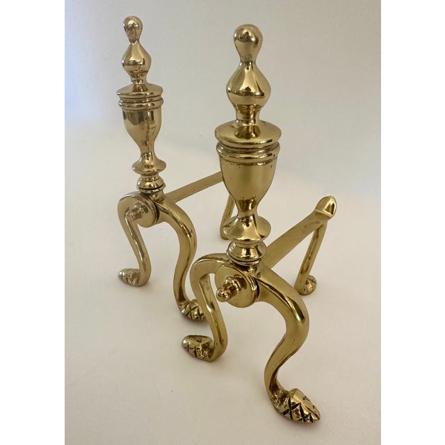 Pair of Victorian brass fire dogs with splayed legs resting on cross feet with urn shaped tops. 3-3/4" W X 6-1/4" D X...