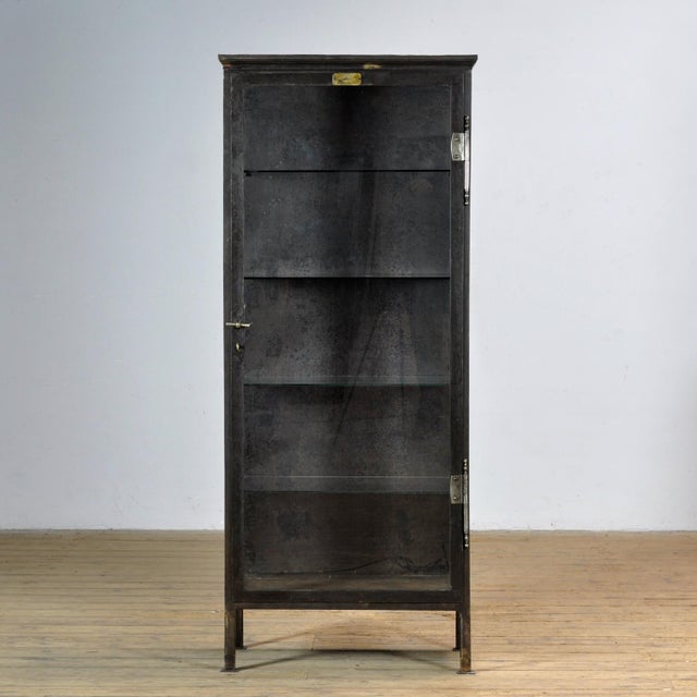 Medical cabinet from the 1910s, manufactured in Budapest, Hungary. This cabinet is made of iron and glass, creating a...
