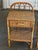 An elegant pair of vintage rattan and wicker bedside tables dating from the 1970s. Their light silhouette, with curved...