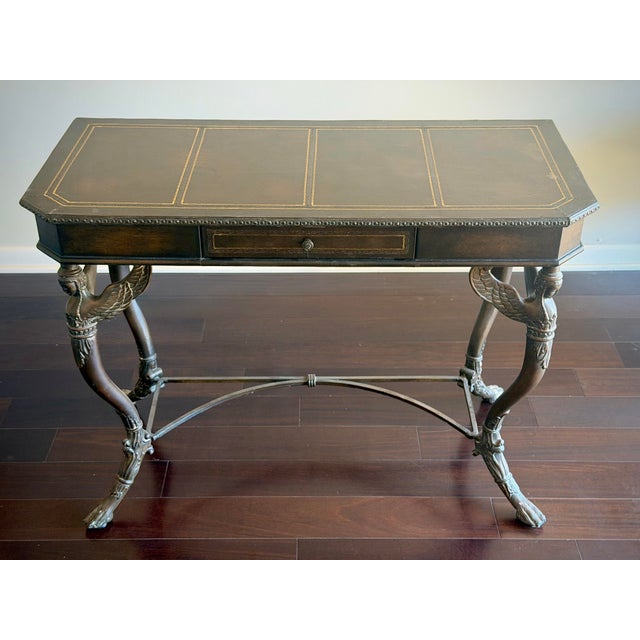 A striking vintage Egyptian Revival console table or writing desk featuring a gilt-tooled leather top, single center...