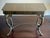 A striking vintage Egyptian Revival console table or writing desk featuring a gilt-tooled leather top, single center...
