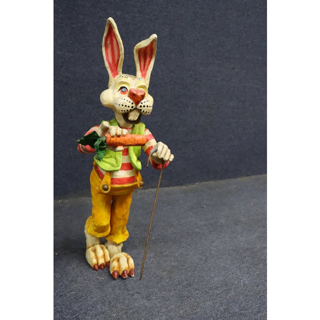 Hand-painted folk art rabbit figure dating to the 1950s, depicted standing upright in a red-and-cream striped shirt, green...