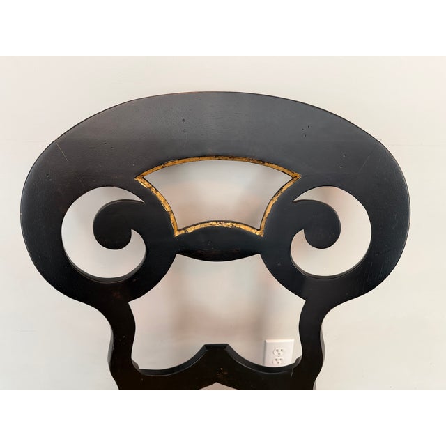 Whimsical side chair finished in a distressed black with gold accents. The seat is covered in a raw silk looking fabric...