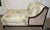 This Ballard Designs chaise lounge features a dark wood frame upholstered in a "Freya Multi" botanical fabric with a...